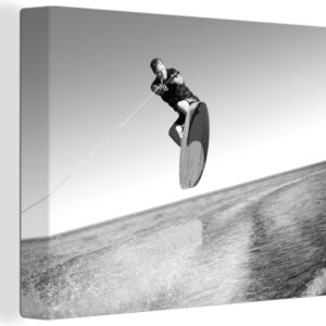 Canvas schilderij 160x120 cm - Wanddecoratie Een man met een wetsuit is aan het wakeboarden op zee - zwart wit - Muurdecoratie woonkamer - Slaapkamer decoratie - Kamer accessoires - Schilderijen