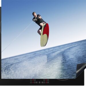 KitchenYeah® Inductie beschermer 57.6x51.6 cm - Een man met een wetsuit is aan het wakeboarden op zee - Kookplaataccessoires - Afdekplaat voor kookplaat - Inductiebeschermer - Inductiemat - Inductieplaat mat